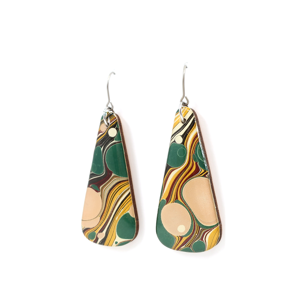 A close-up view of green, yellow, pink, and beige mid-century modern long earrings made from hand marbled UK paper and coated with UV-cured resin.
