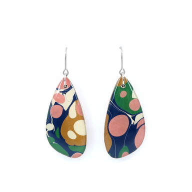 Close-up view of navy and pink modern marble dangle earrings showcasing their intricate design made from laser cut wood and nickel-free titanium hooks.