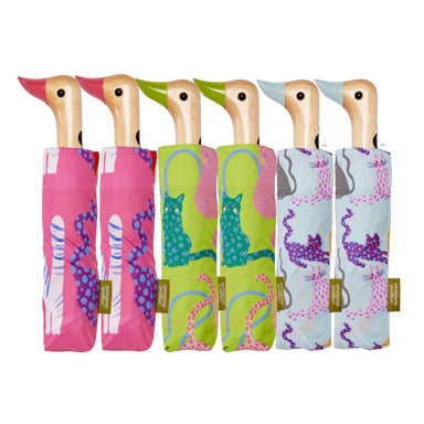 Colorful Arty Cats Duck Umbrellas featuring charming duck-head handles, designed by Original Duckhead USA. Each umbrella showcases playful cat designs in fuchsia, lime, and ice colors, made from recycled materials and sustainably sourced birch wood.