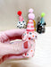 Lovely mini party dog in soft pink with colorful dots and a striped red party hat, created by Bianca Rae. A delightful piece from 'Party Minis! Mini Party Dogs in Party Hats.'