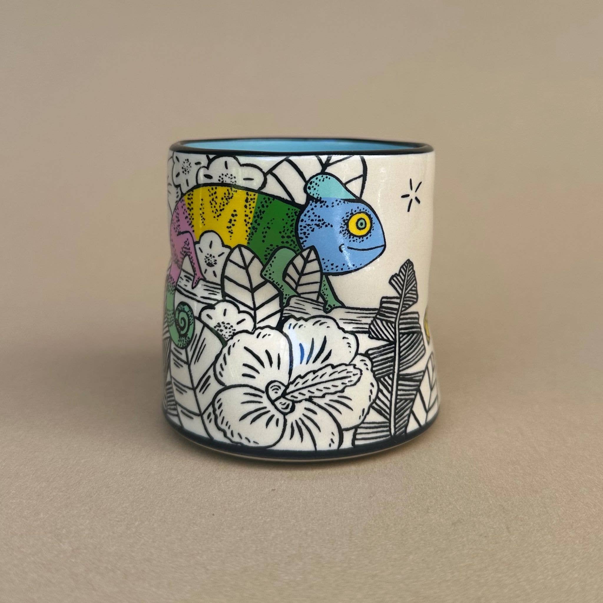 Lucky Chameleon Cup - Medium by The Bowl Maker showcases a vibrant chameleon illustration surrounded by flowers and leaves, ideal for nature lovers.