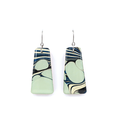 Close-up of light blue and navy mid century modern marble dangle earrings featuring unique patterns from hand-marbled paper.