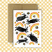 Greeting card with black rabbit illustrations and rainbows on a white background, with a brown envelope.