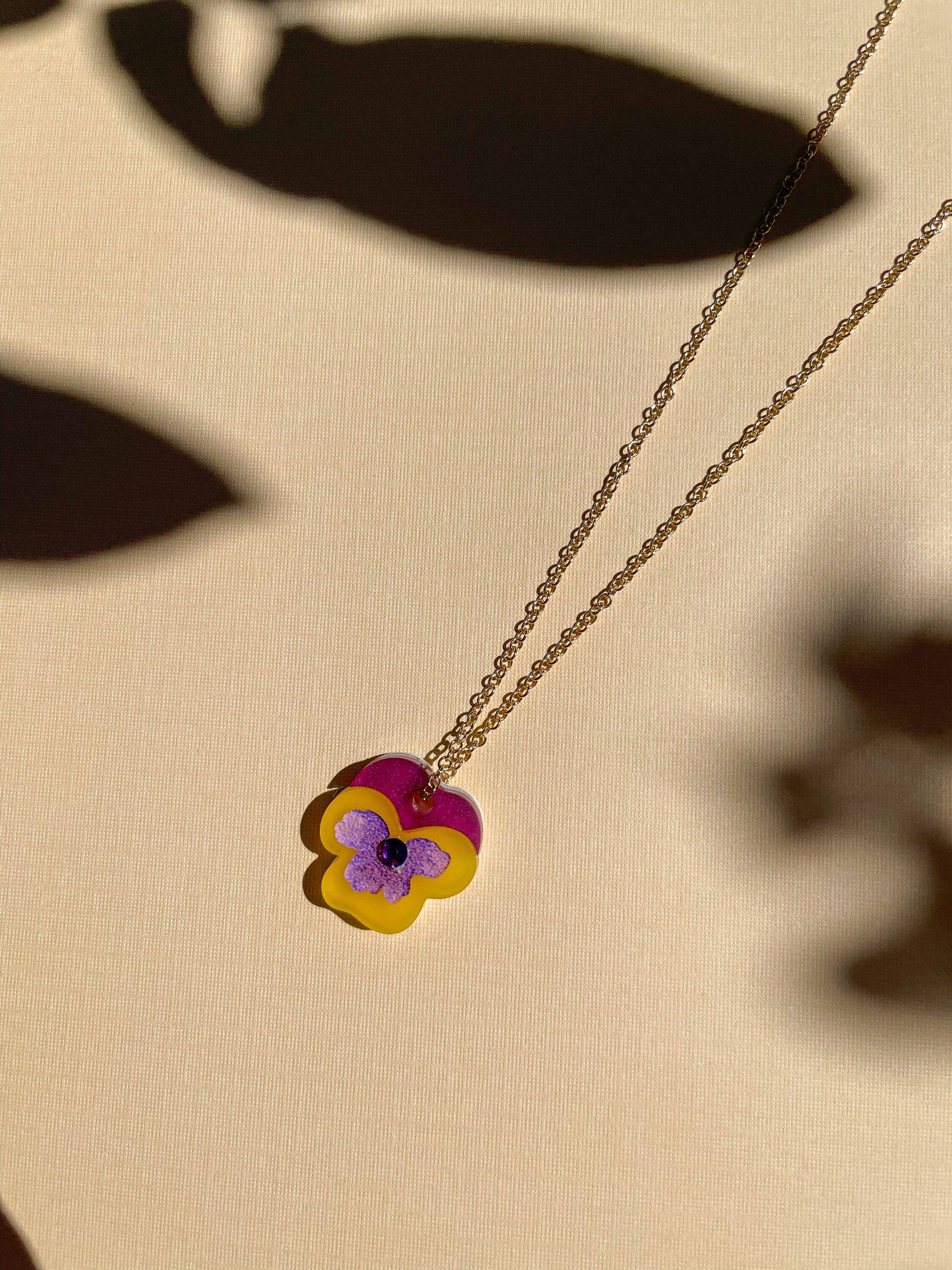 Single Mini Pansy Necklace by Sunnie Creative with a vibrant purple and yellow flower design, highlighting the intricate detail of the handmade piece.