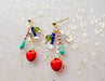 Colorful Heart Charm Earrings by Jill Makes, featuring a variety of glass, acrylic, and Czech beads, with red heart charms, hanging elegantly against a sparkling background.