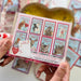Boxed Set of 16 Kids Valentines Cards Kit by The Red Barn Press. The back of the card set displays various animal-themed Valentine cards and envelopes, emphasizing fun designs and heart stickers.