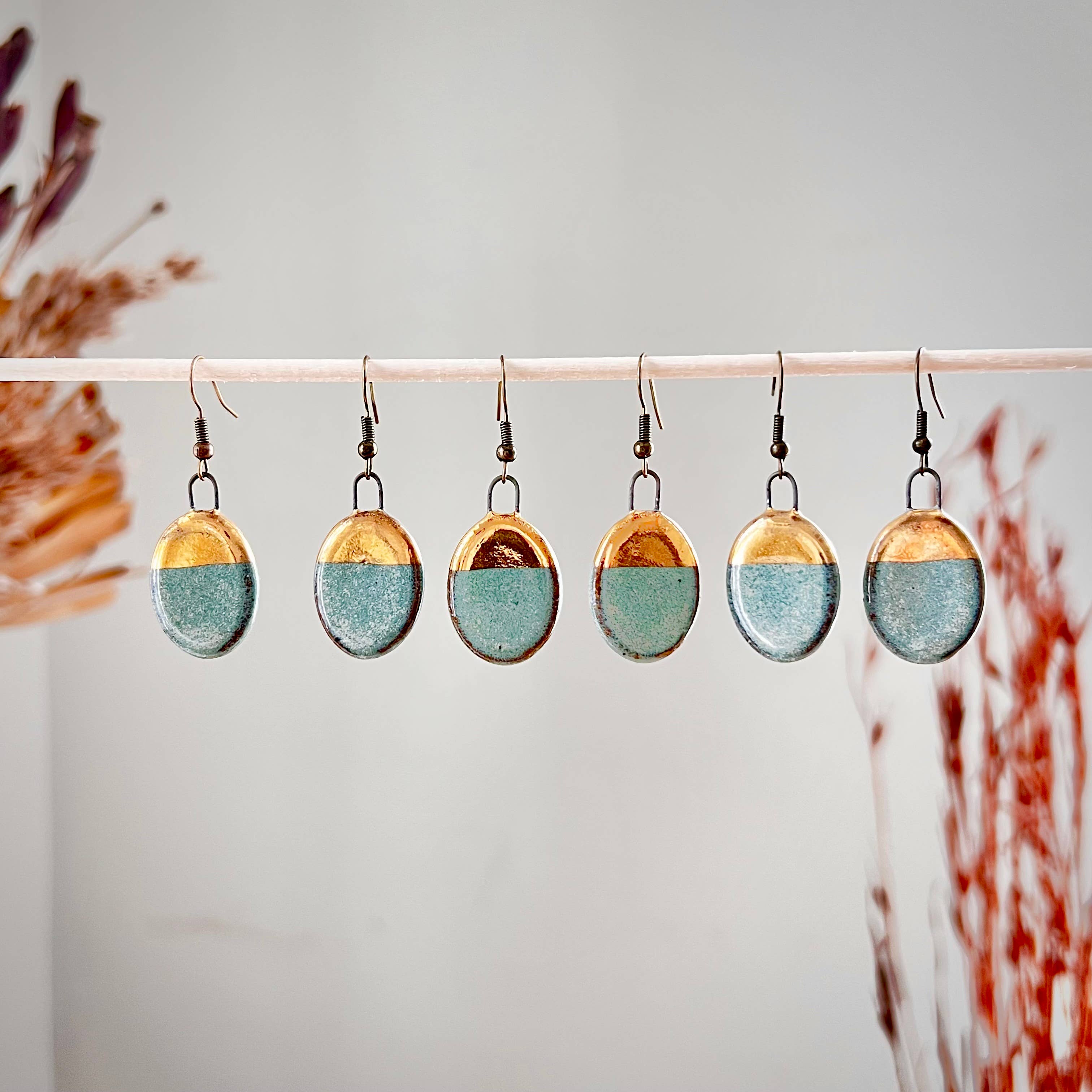 Multiple pairs of Turquoise Dipped Oval Gold Earrings by The Artifact House, highlighting the artistic handmade details and variations in design.