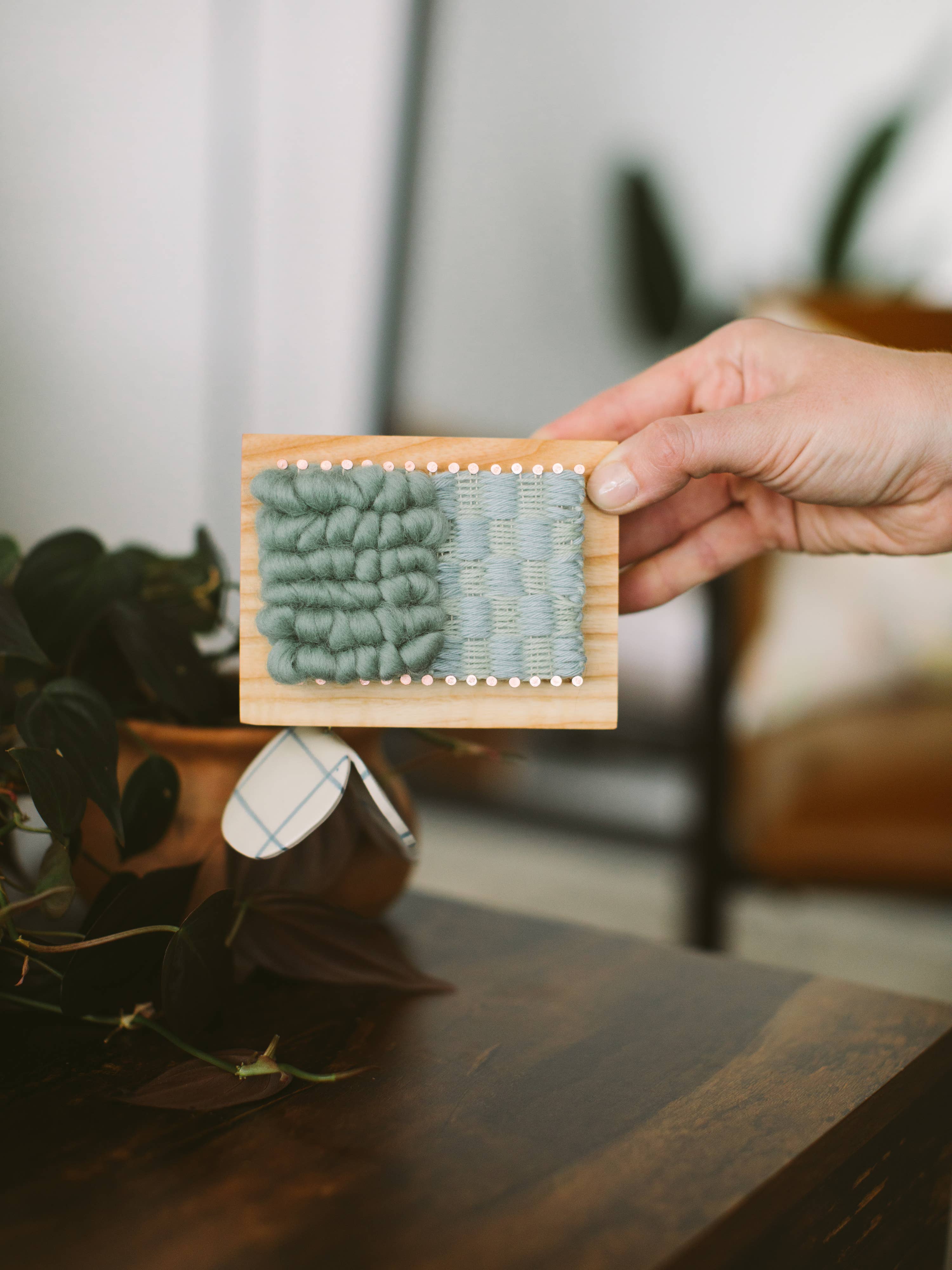 person holding hand woven pin block