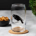 Enjoy a drink in style with the Crow Beer Can Glass - 16oz, Dishwasher Safe and Hand-Drawn, designed to add a macabre twist to your happy hour!