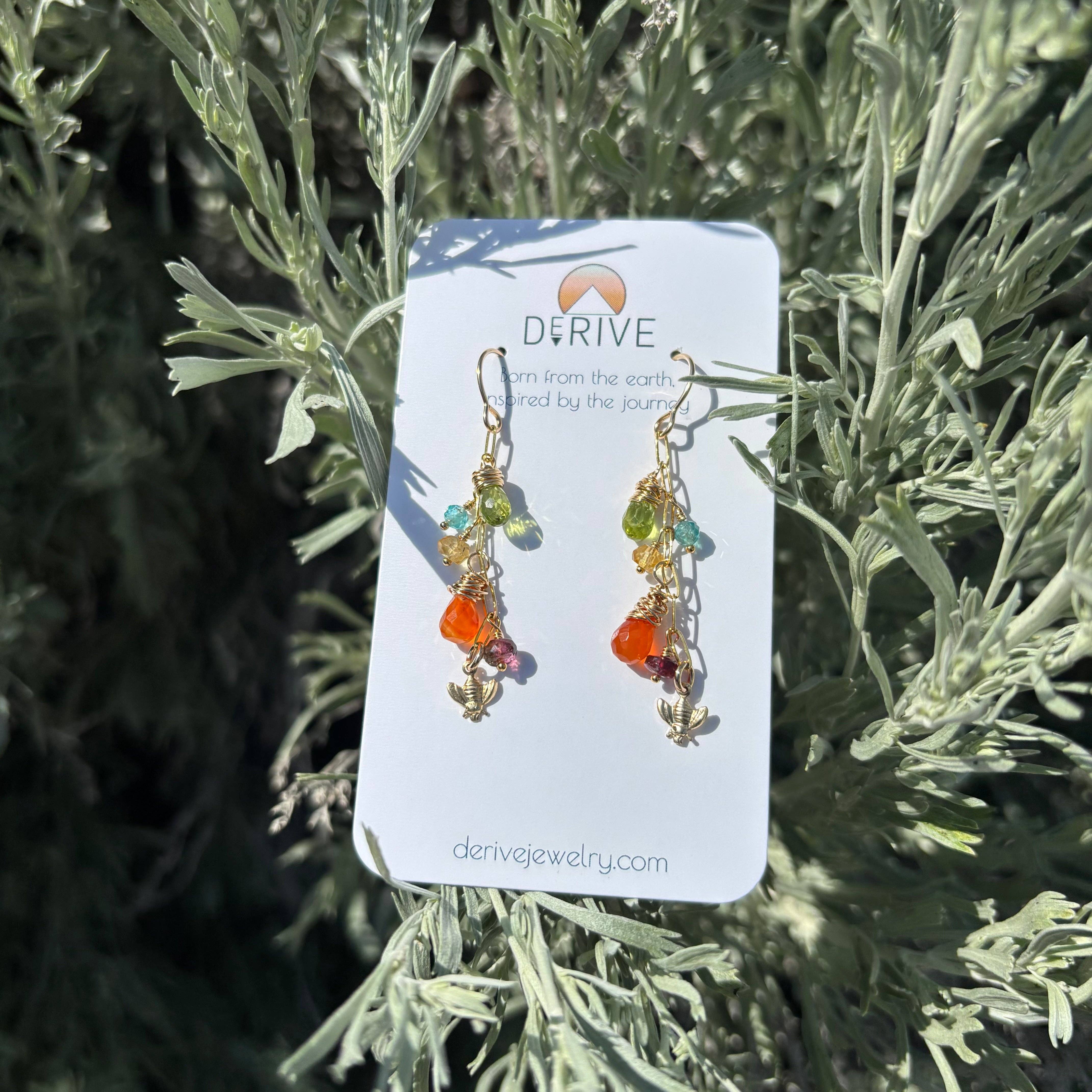 Whimsical Wildflower Earrings featuring a tiny bee charm, adorned with vibrant gems like carnelian and tourmaline, making your ear game the bee's knees!