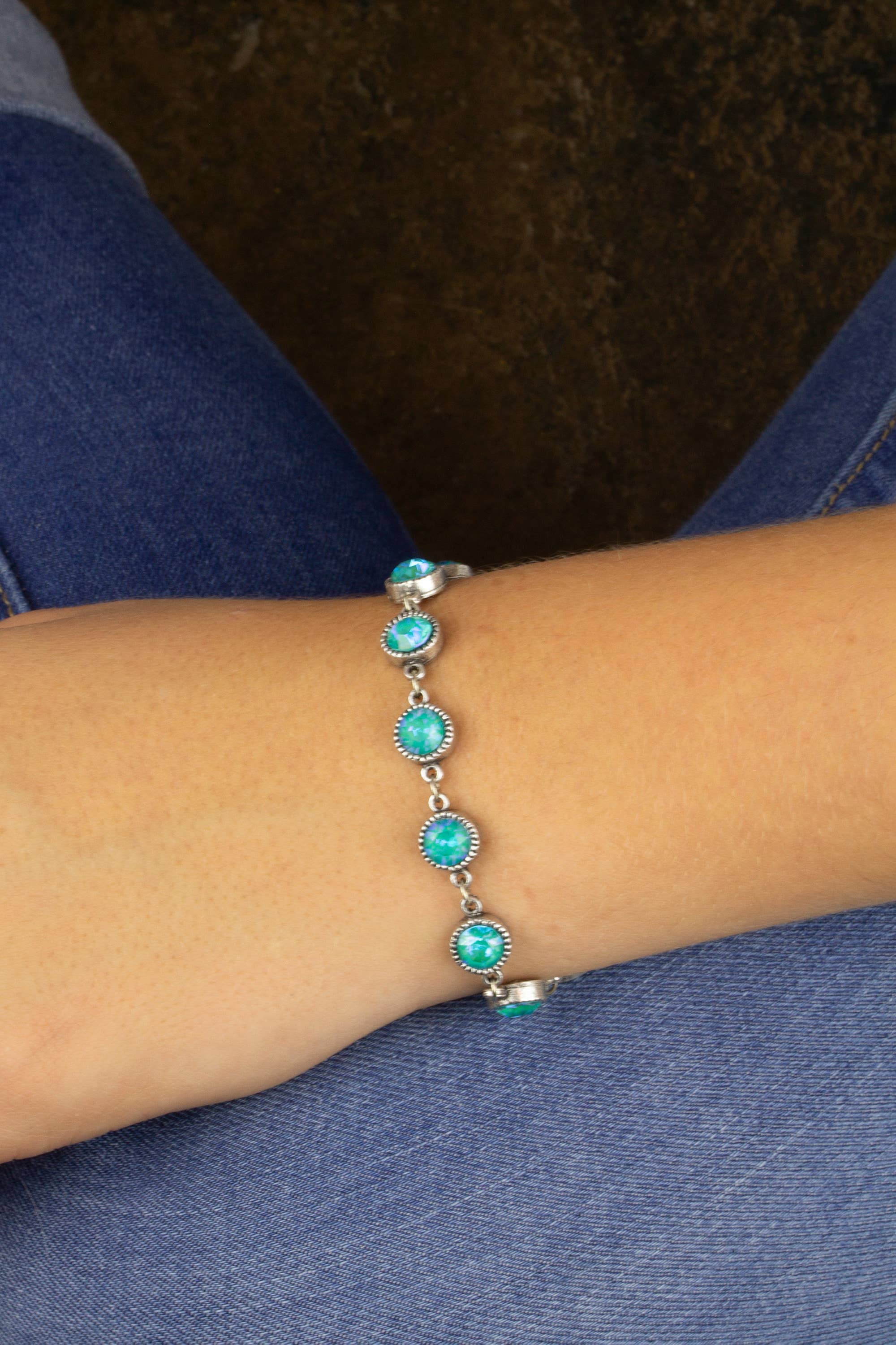 Turquoise beaded bracelet on a wrist with a denim background