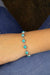 Turquoise beaded bracelet on a wrist with a denim background