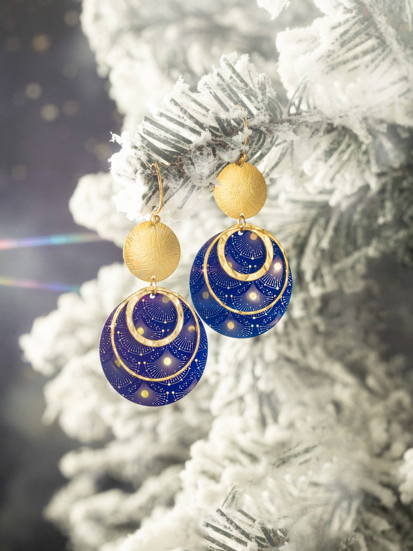 Close-up of the Atlas Earrings by Holly Yashi, showcasing two shimmering gold metal hoops and a bold sun, ready to take your style to the universe!