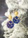 Close-up of the Atlas Earrings by Holly Yashi, showcasing two shimmering gold metal hoops and a bold sun, ready to take your style to the universe!