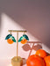 Stylish Orange Dangle earrings presented on a display stand with oranges, highlighting the intricate design and bright colors crafted by Sunnie Creative.