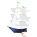 Dark navy blue and white Sailing Ship Kite by Haptic Lab, held by a person, highlighting its craftsmanship and unique appearance.