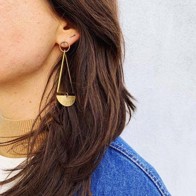 woman wearing kinetic brass and bronze triangle hoop stud earrings