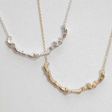 Two silver and gold necklaces with gemstones