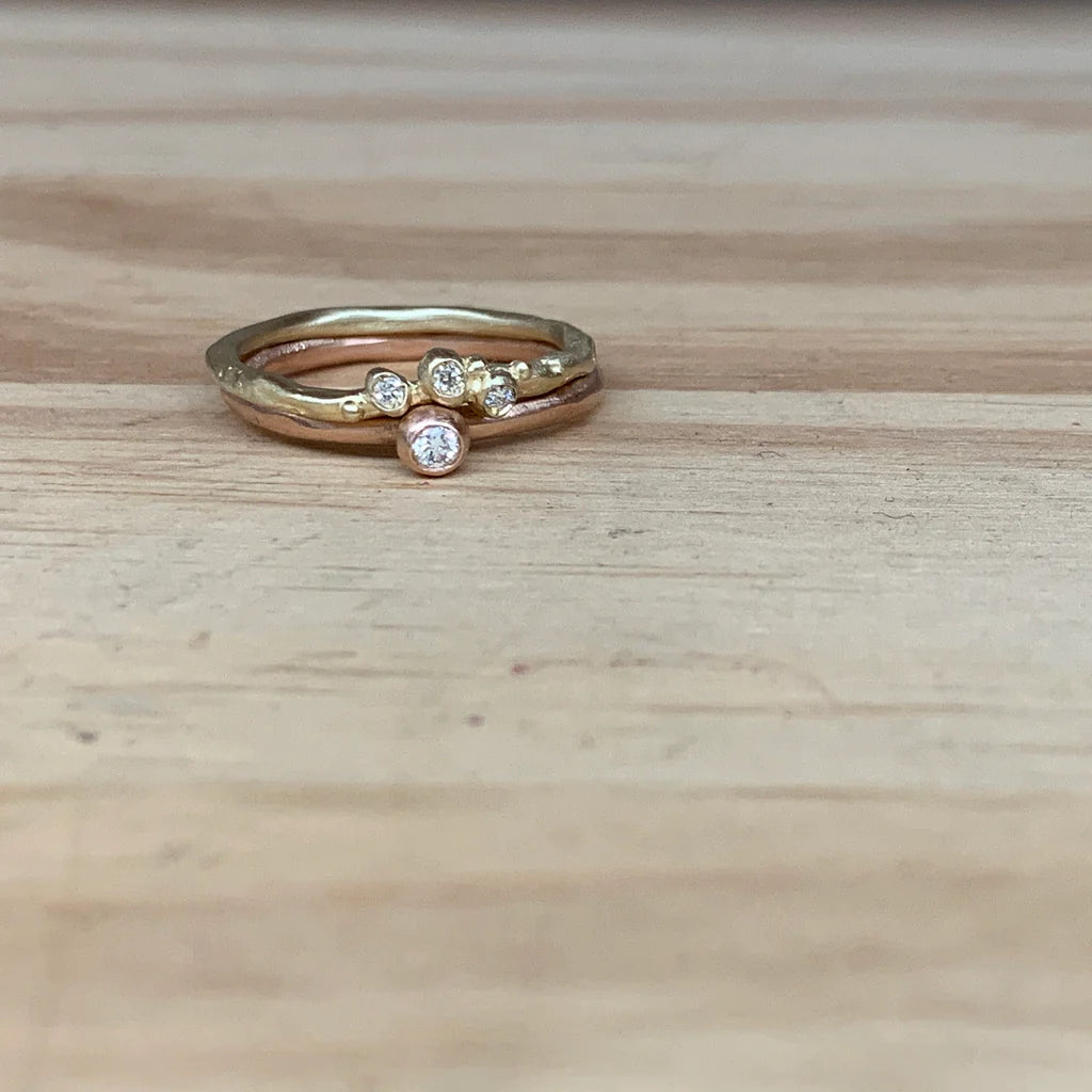 Stack of gold and rose gold rings with embedded diamonds 