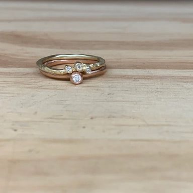 Stack of gold and rose gold rings with embedded diamonds 