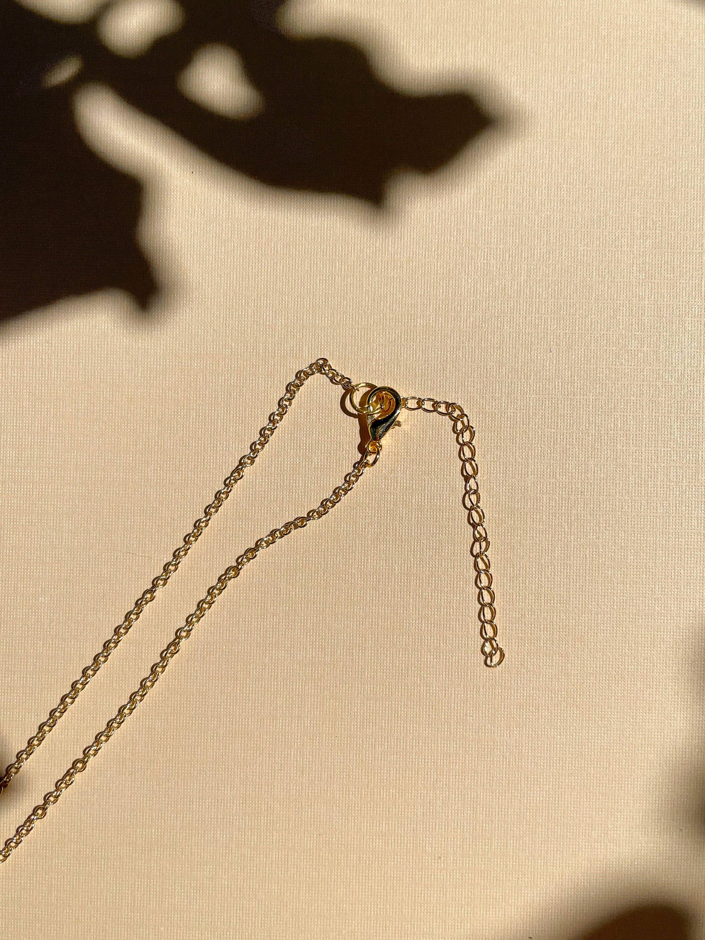 Close-up view of the gold lobster clasp and extension of the Mini Lemon Necklace by Sunnie Creative, highlighting its quality craftsmanship.