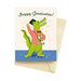 Playful graduation card showcasing a cartoon crocodile in a graduation cap holding a diploma, with the text 'Snappy Graduation!' created by ARTISANS & agency in the Graduation Card Collection.