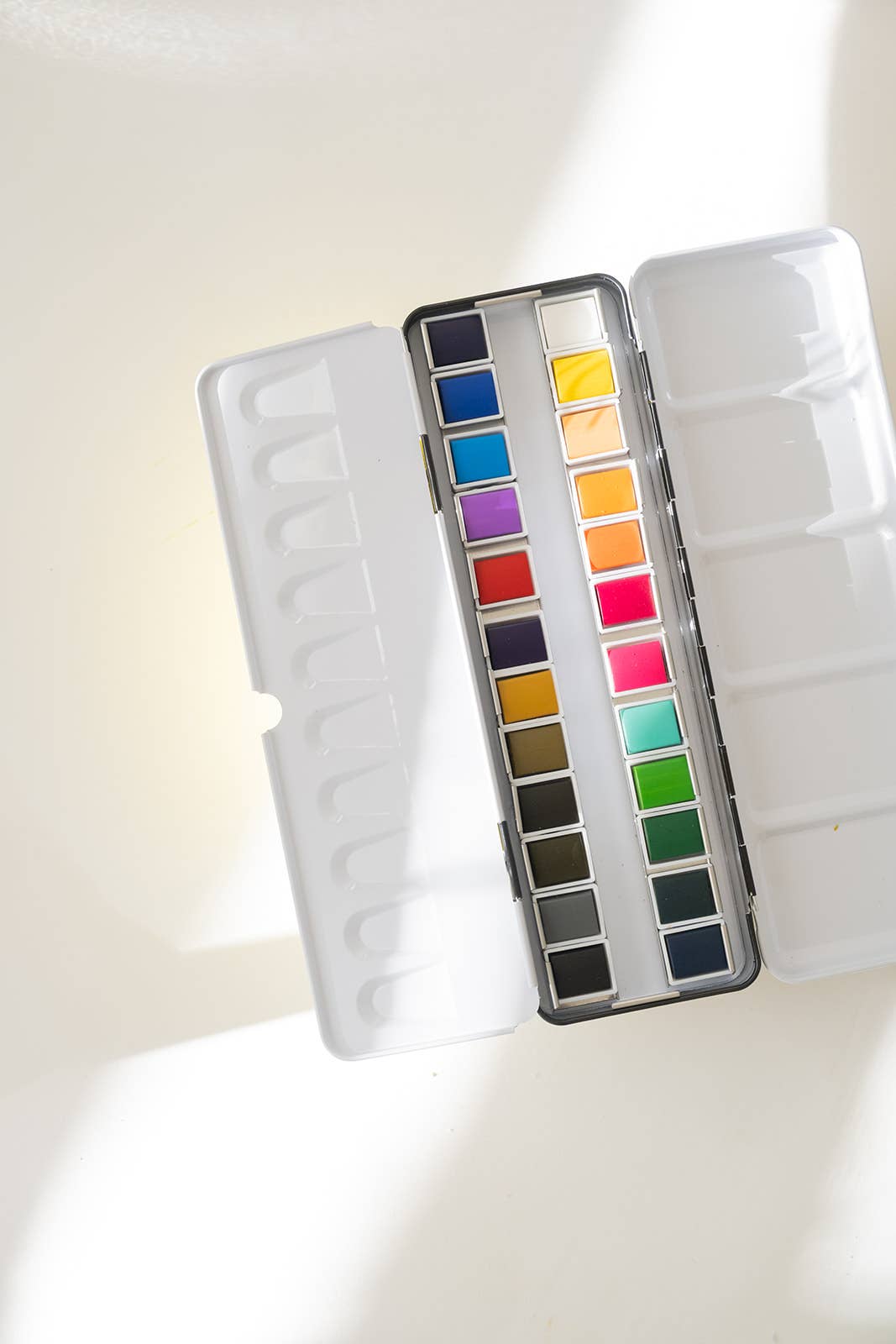 Artist using the 24 Color Watercolor Paint Palette outdoors, demonstrating its portability and versatility in creative projects.