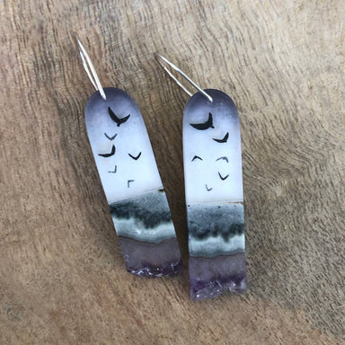 Crystal Flock Earrings by Fernworks featuring tiny dark bird designs layered in polished resin, accented with polished amethyst and jasper, measuring approximately 1.5" x 0.5" with sterling silver ear wires.