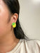 Close-up of a person wearing Mini Lemon Dangle earrings, featuring the bright yellow acrylic and green leaf design by Sunnie Creative.