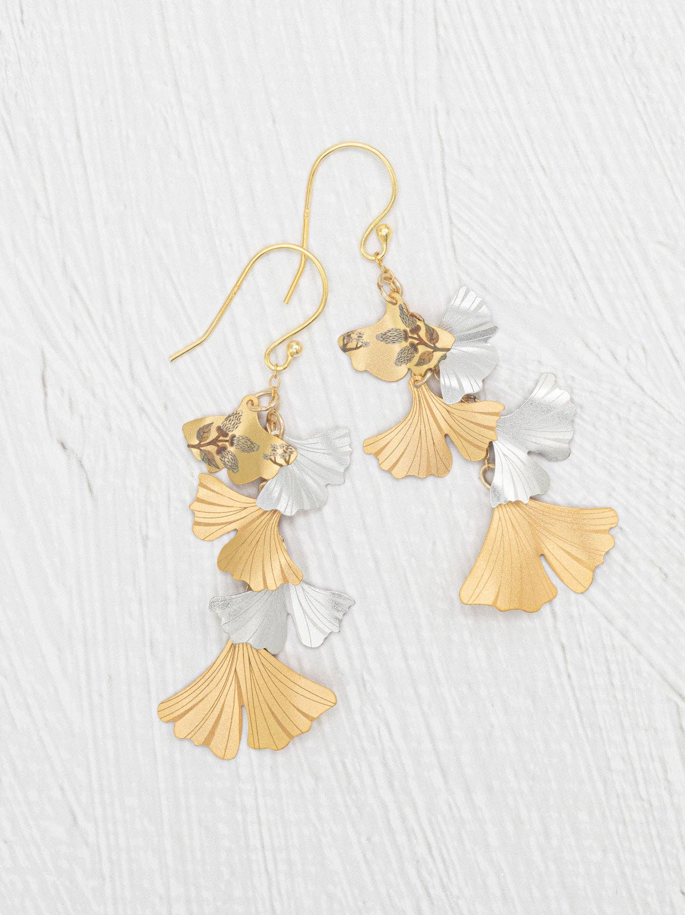 Catch some fluttery vibes with these Fluttery Ginkgo Drop Earrings—where sculpted leaves in soft gold and silver tones play peek-a-boo as they stylishly swirl around your ears. Perfect for those who want their jewelry to dance as much as they do!