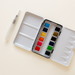 Compact 12 Color Mini-Travel Watercolor Paint Palette showing vibrant colors, perfect for travel and workshops.