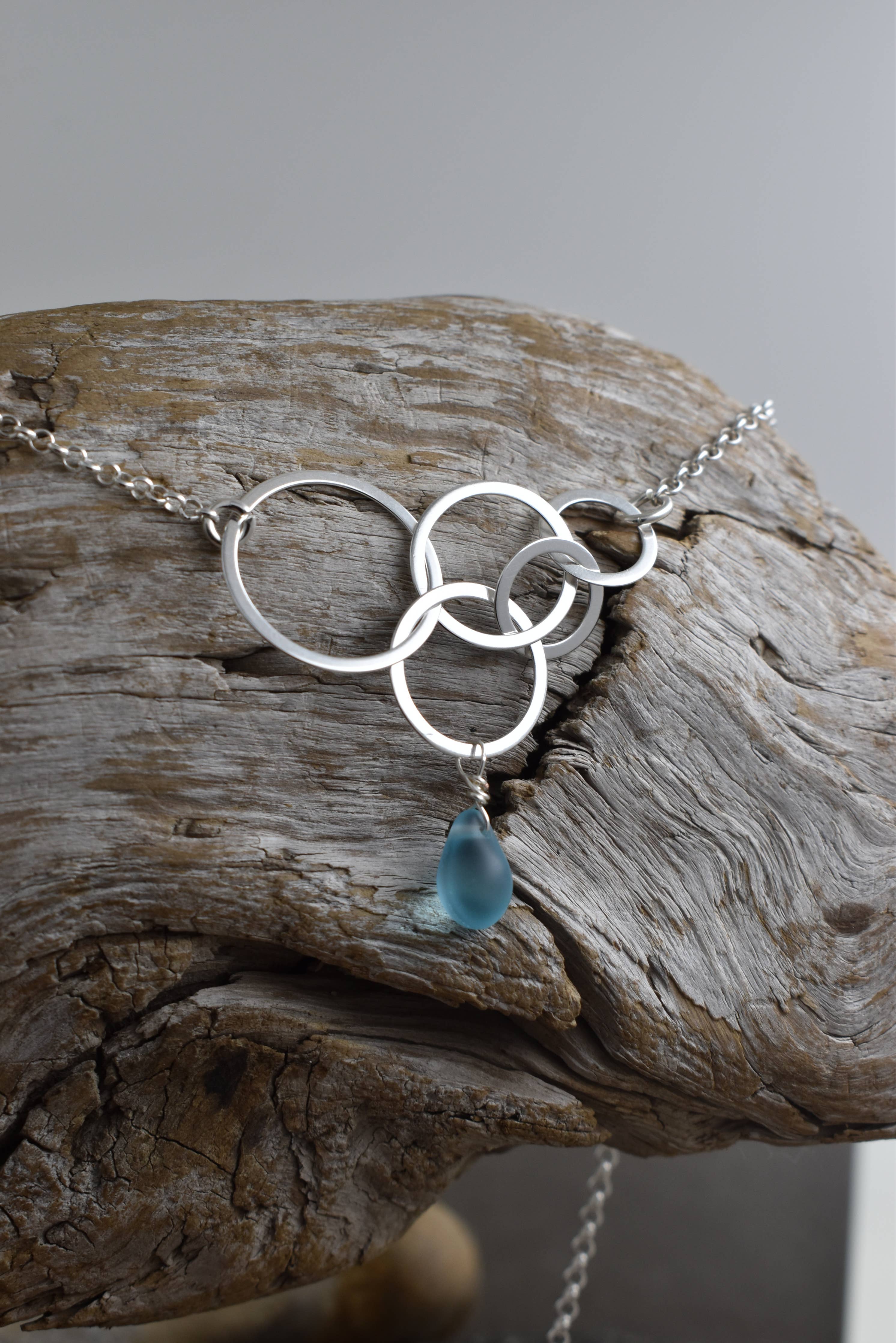 Close-up of the Aqua Eco Glass Sterling Silver Circle Necklace featuring the handcrafted aqua Eco Glass teardrop pendant with a frosted finish.