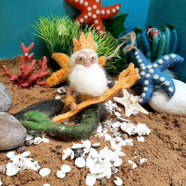 Felted poseidon ornament with a crown, white beard, and pitchfork with a sandy backround