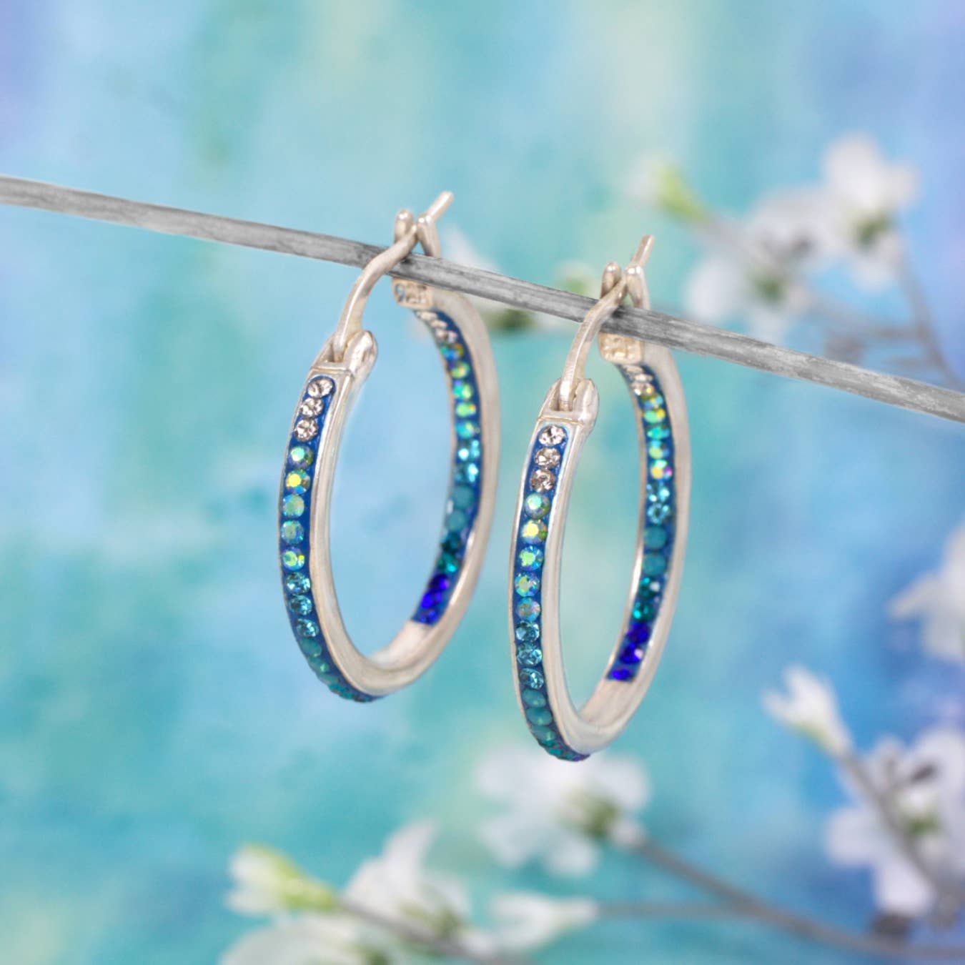 Close-up view of Mosaico Jewels crystal and silver extra large hoop earrings showcasing their unique double-sided sparkle and design.