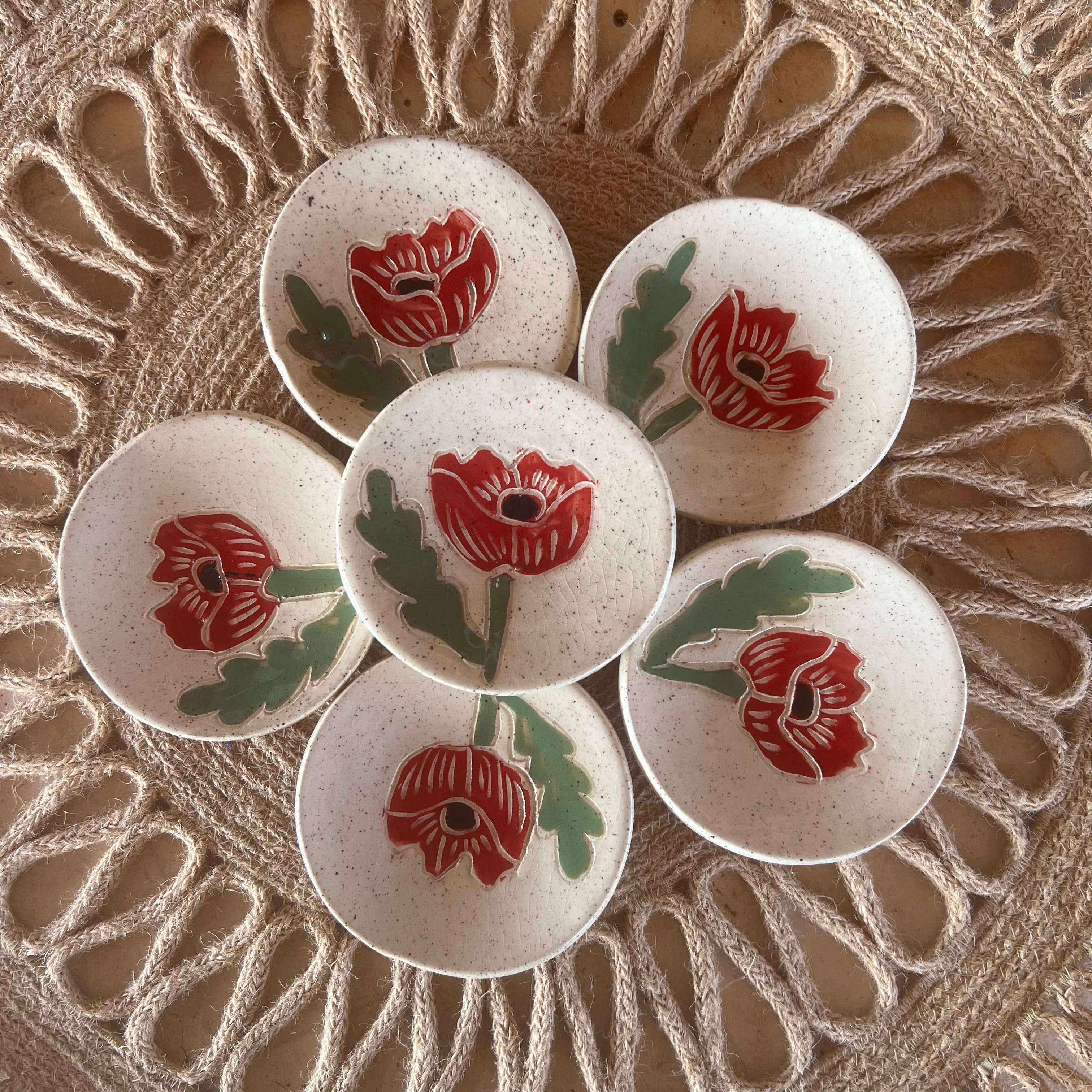 Handcrafted Red Poppy Tea Rest by Tough Kitty Designs featuring a circular dish with red poppy flower design, perfect for holding trinkets, tea bags, or spices. Each unique mini dish measures 3 inches in diameter.