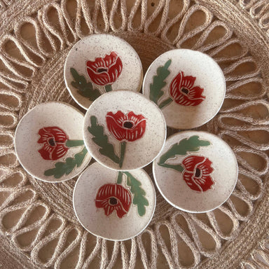 Handcrafted Red Poppy Tea Rest by Tough Kitty Designs featuring a circular dish with red poppy flower design, perfect for holding trinkets, tea bags, or spices. Each unique mini dish measures 3 inches in diameter.