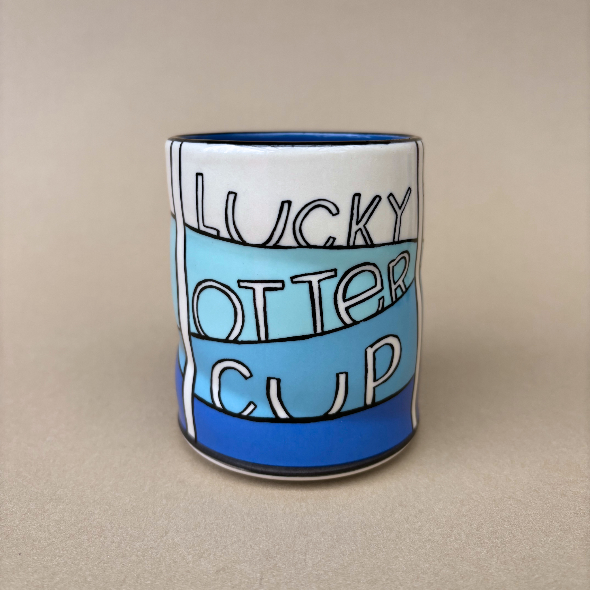 Lucky Otter Cup showcasing the text 'LUCKY OTTER CUP' in colorful lettering, crafted by The Bowl Maker.