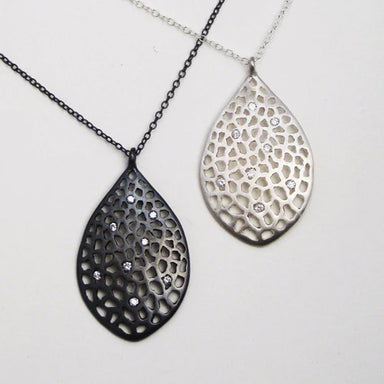 Two silver laced teardrop pendants with small diamonds on chains 