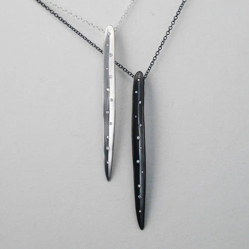 Two long, thin pendants with small diamonds on a chain