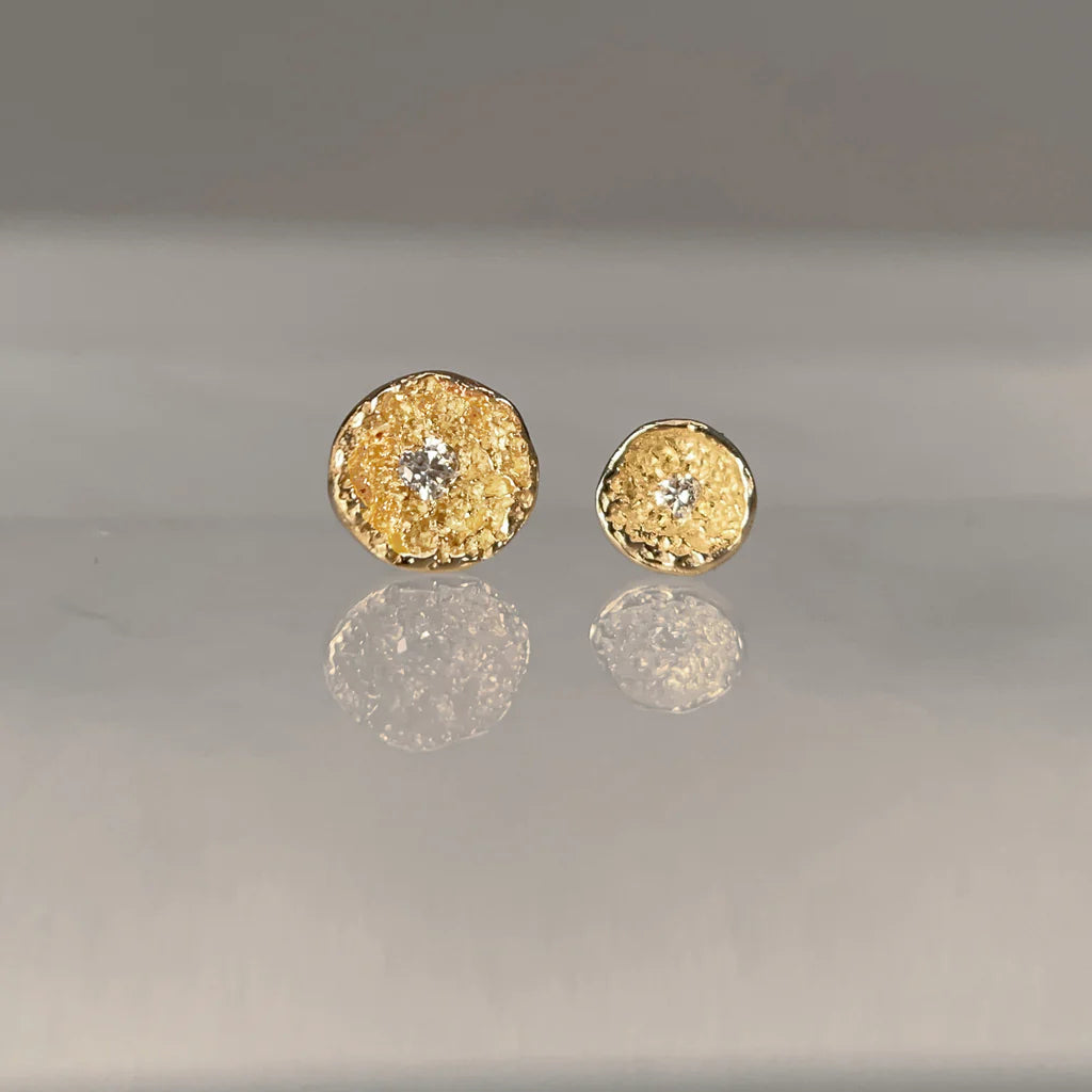 Gold textured round earrings with a central gemstone 