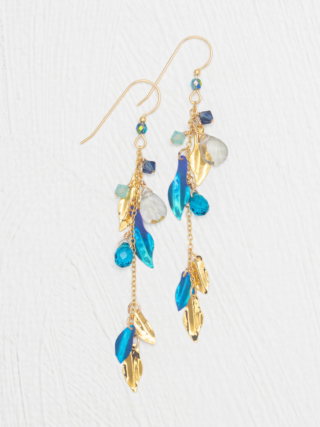 Calliope Earrings designed by Holly Yashi featuring niobium and gold leaves, adorned with quartz, crystals, and natural gemstones, showcasing a playful and polished cascade design.
