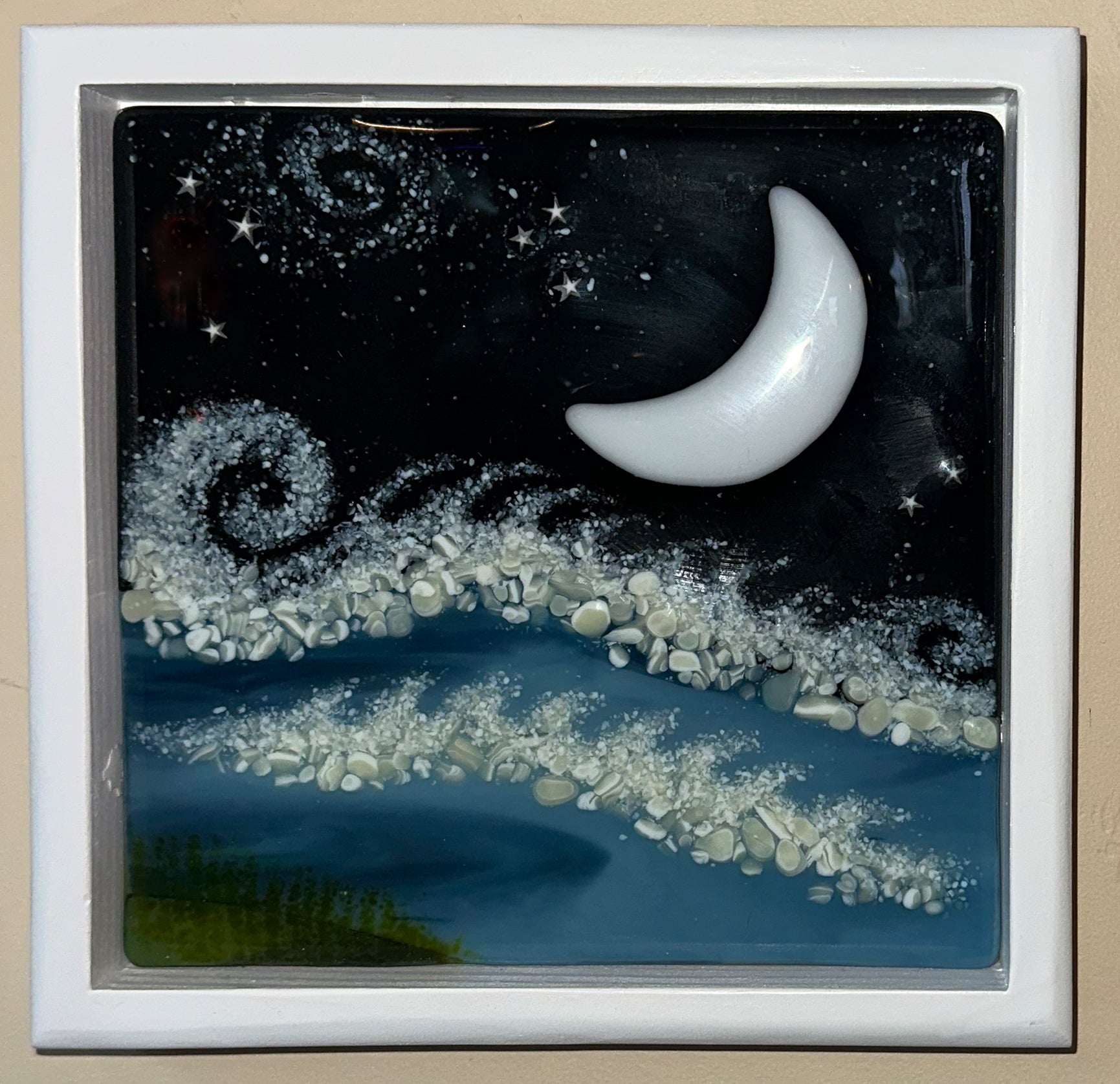 Fused glass painting titled 'Moonlight in Paradise' by Hearts for the Arts. The artwork features a serene night scene with a crescent moon illuminating gentle waves and a starry sky, reflecting a tranquil bay atmosphere.