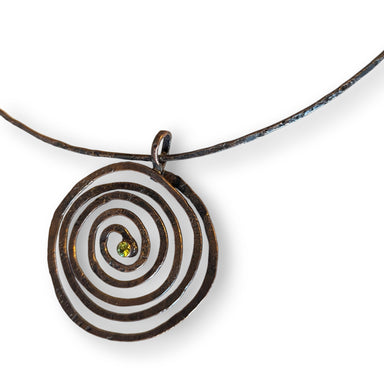 Spiral choker necklace with faceted peridot, handcrafted by Deb Collins, featuring a copper design inspired by organic shapes.